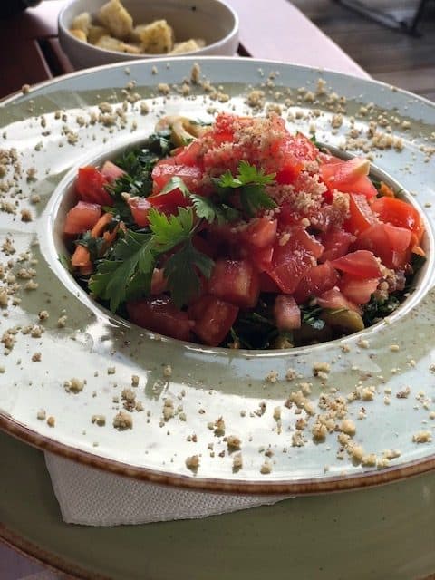 Bol cu salată de roșii și pătrunjel, presărată cu firimituri