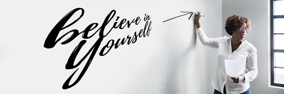 Femeie scriind pe perete caligrafia „Believe in Yourself"