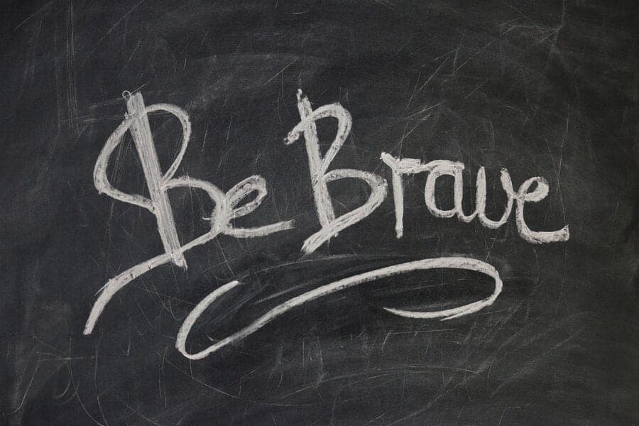 Tablă neagră cu textul scris cu creta „Be Brave”