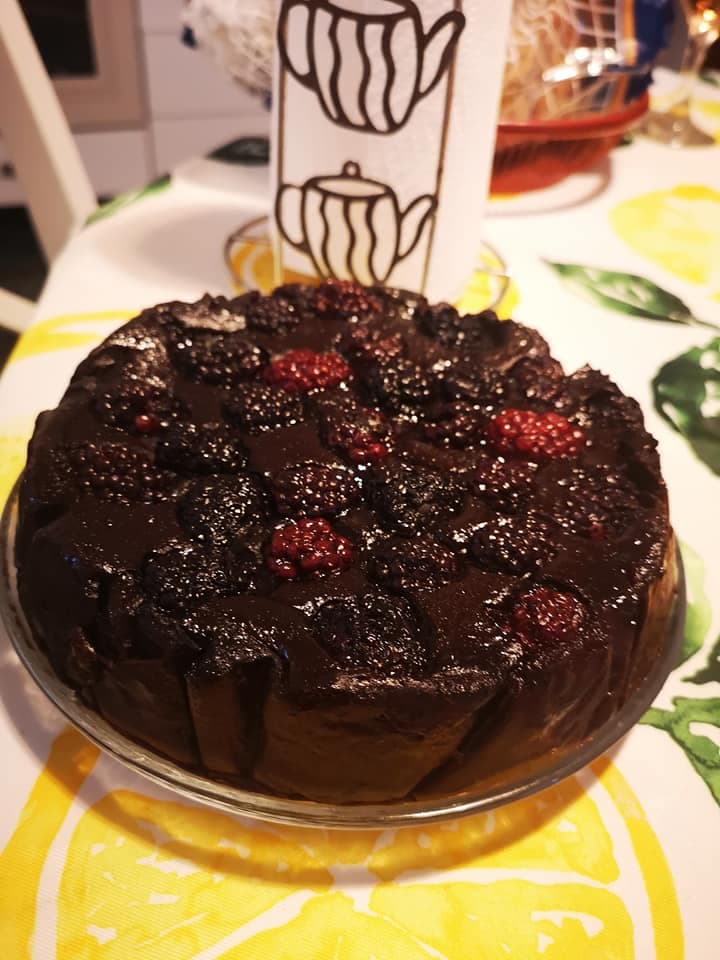 Tort de ciocolată glazurat, decorat cu zmeură și mure