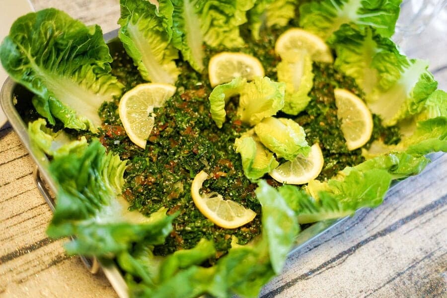 Salată verde tocată cu felii de lămâie și frunze de salată