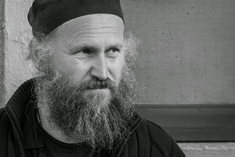 Portret alb-negru al unui bărbat cu barbă lungă și scufie neagră
