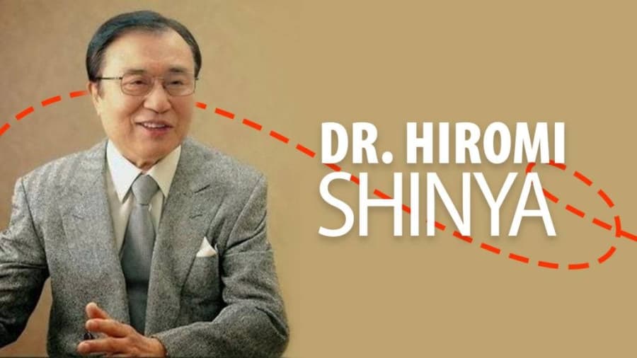 Banner cu un bărbat în costum și textul „DR. HIROMI SHINYA”