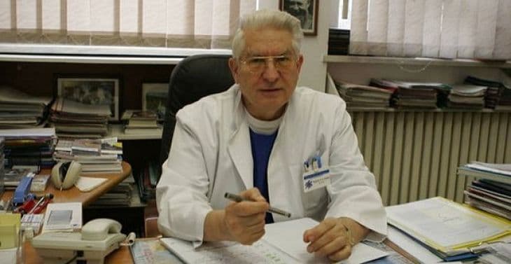 Bărbat în halat alb, la birou într-un cabinet medical