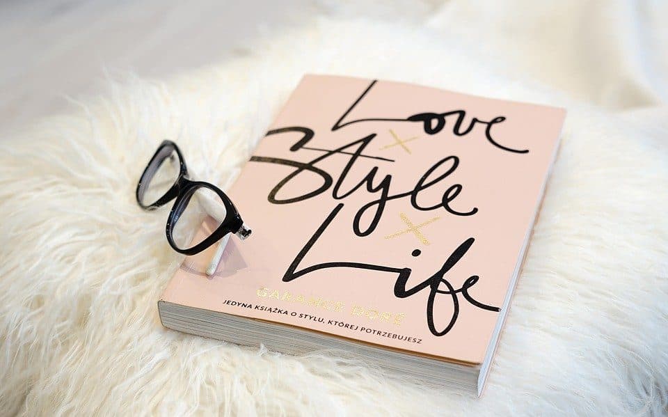 Carte cu titlul „Love Style Life” și ochelari, pe blană albă