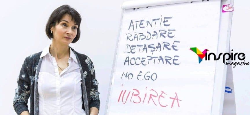 Femeie lângă un flipchart: „Atenție, răbdare, detașare, acceptare, no ego, iubirea”