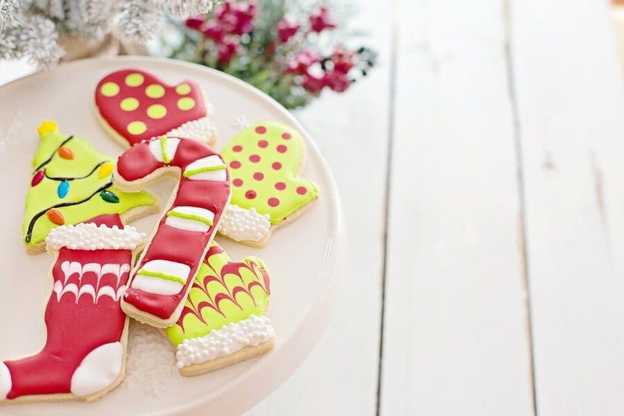 Biscuiți de Crăciun cu glazură colorată, pe un platou alb
