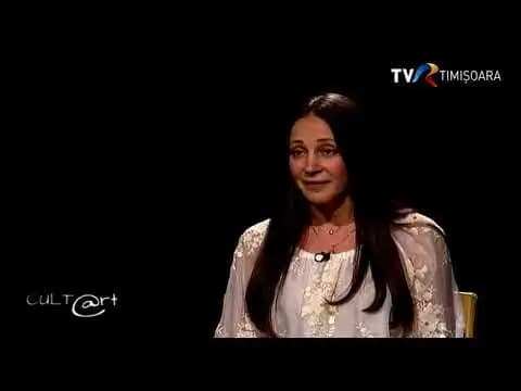 Femeie în bluză albă într-o emisiune TV, sigla „TVR Timișoara”