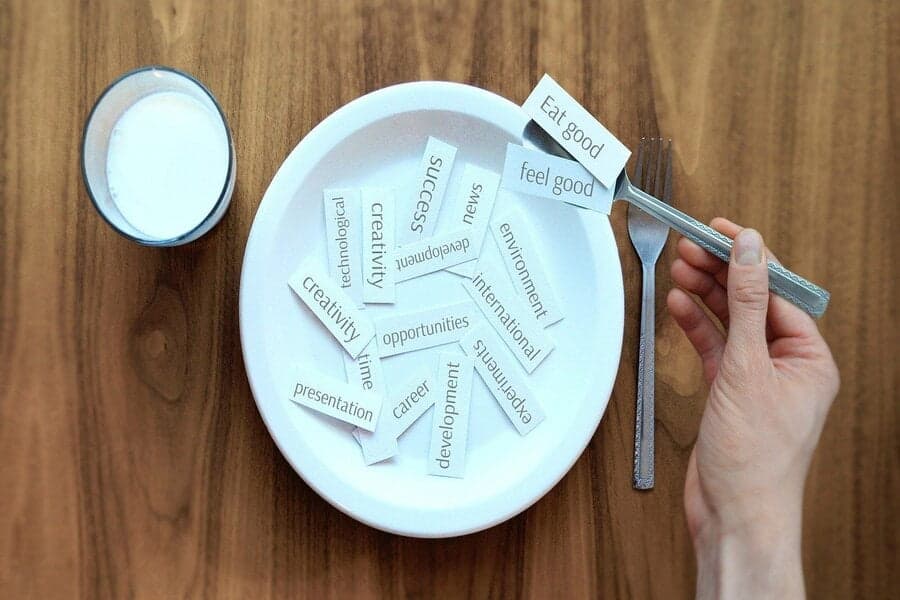 Farfurie cu bilețele de hârtie, pe furculiță scrie „Eat good, feel good”