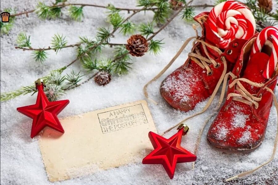 Ghetuțe roșii în zăpadă, stele și un card ștampilat „A Happy Christmas”