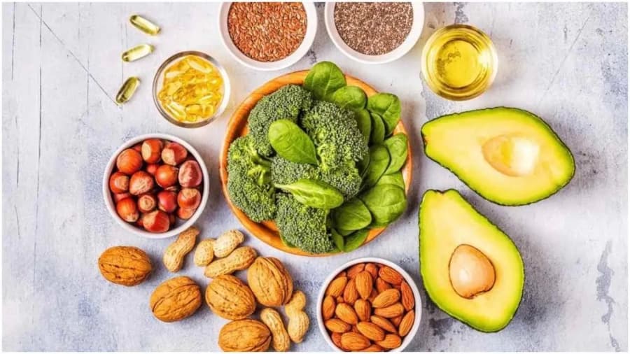 Avocado, nuci, semințe, broccoli și ulei așezate pe o masă