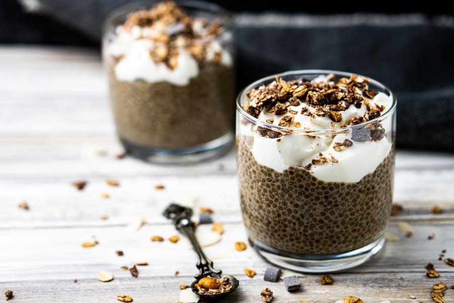 Două pahare cu budincă de chia, iaurt și granola