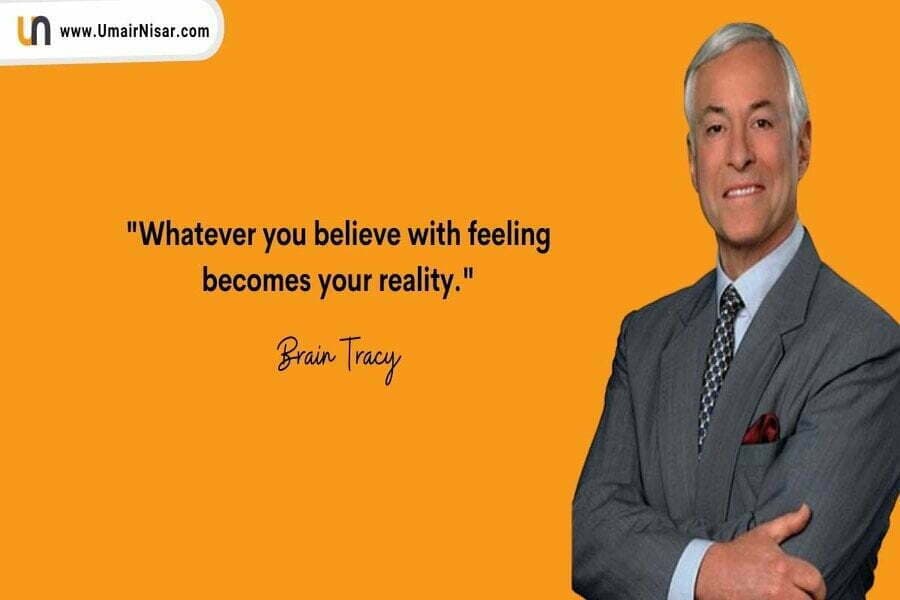 Card portocaliu cu citatul „Whatever you believe with feeling becomes your reality”, semnat Brain Tracy, lângă un bărbat în costum