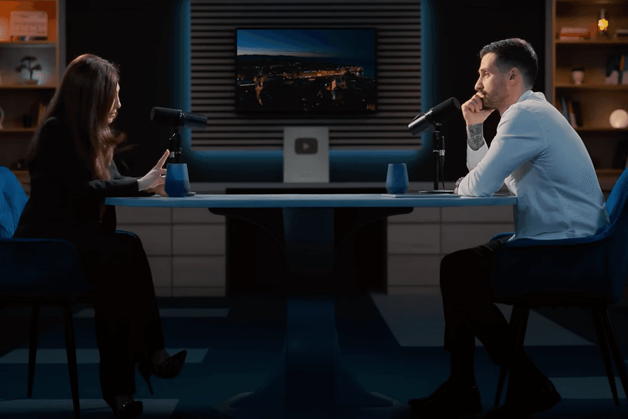 Doi participanți la un podcast, față în față la microfoane